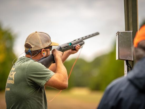 shooter aiming shotgun outside